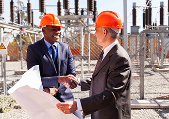 Workers in hard-hats on a worksite, studying blueprints