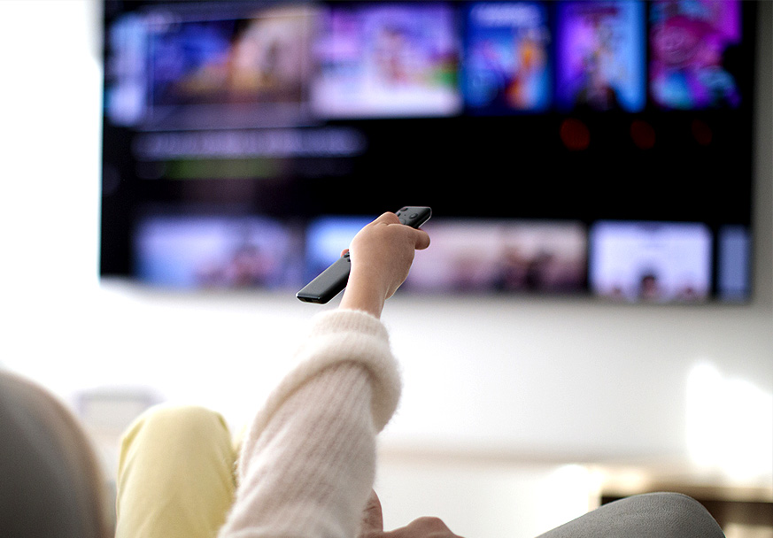 Fingers adjusting the settings on a digital thermostat
