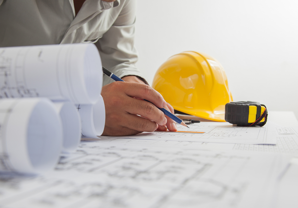 Closeup of hands marking up a blueprint with a pencil