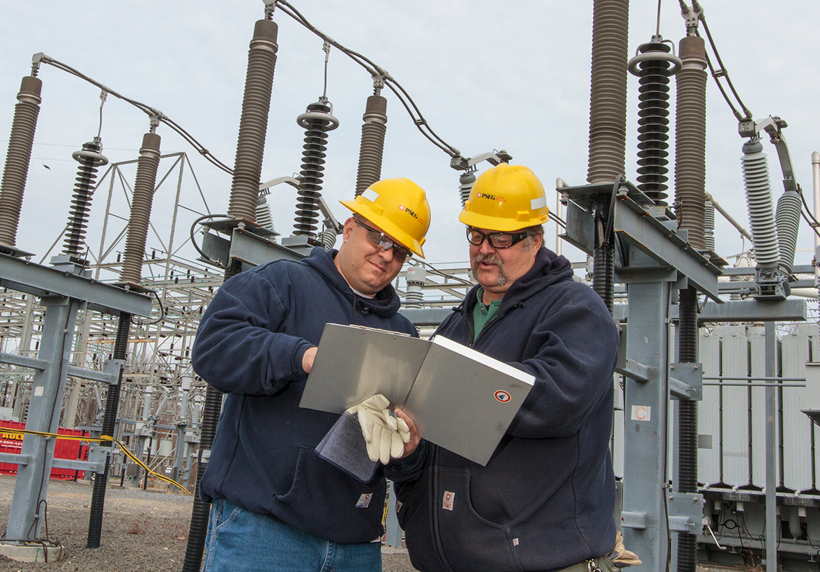 Two men in hard hats looking at plans