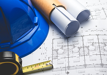 Building plans, hardhat and measuring tape