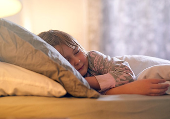 a woman sitting in front of a window drinking coffee