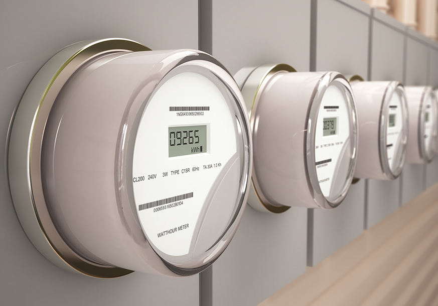 Closeup of a set of electric meters mounted on a wall in an industrial setting