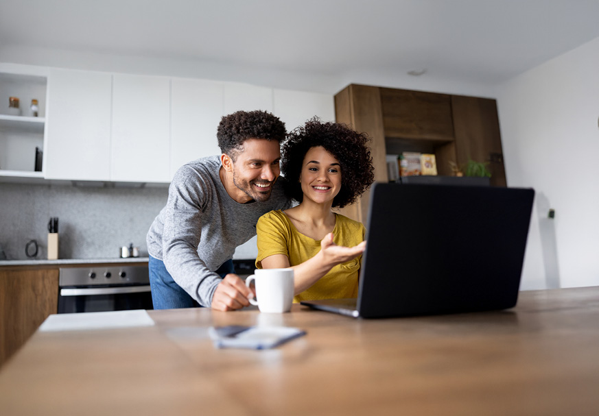 A couple looking at a tablet and a piece of paper