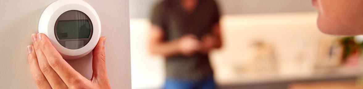 woman controlling thermostat